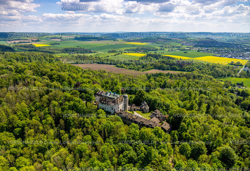 Brakel240504788SchlossHinnenburg | Luftbild, Schloss Hinnenburg auf einer Bergkuppe im Waldgebiet, Privatbesitz der Familie von der Asseburg-Falkenstein-Rothkirch, Fernsicht mit blauem Himmel und Wolken, Hinnenburg, Brakel, Ostwestfalen, Nordrhein-Westfalen, Deutschland