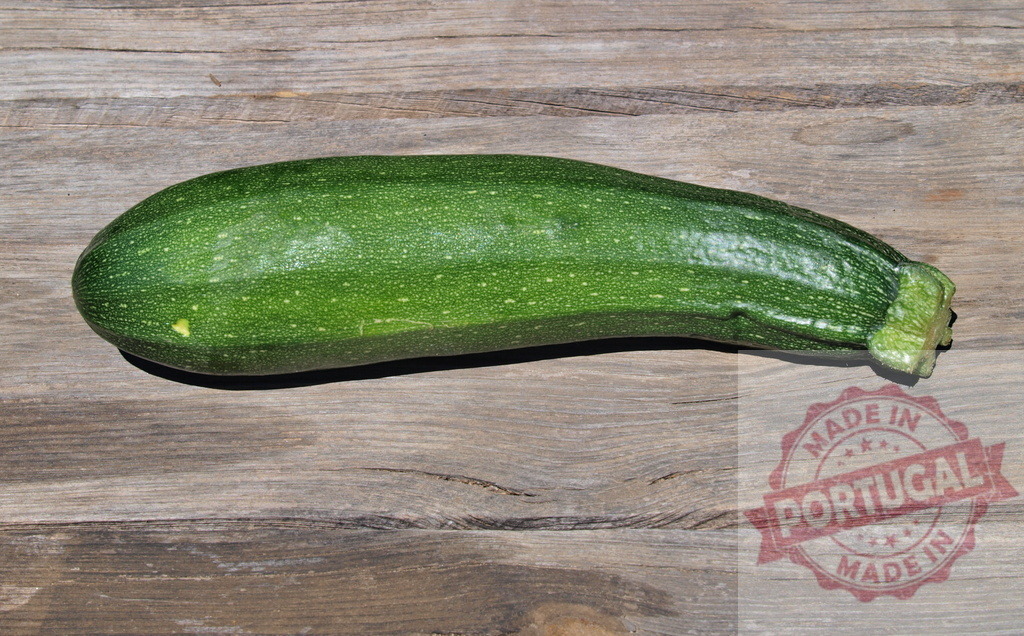 Fresh green zucchini vegetable on wooden surface | Zucchini laying on rustic wooden planks, representing fresh harvest and healthy eating - Realisiert mit Pictrs.com