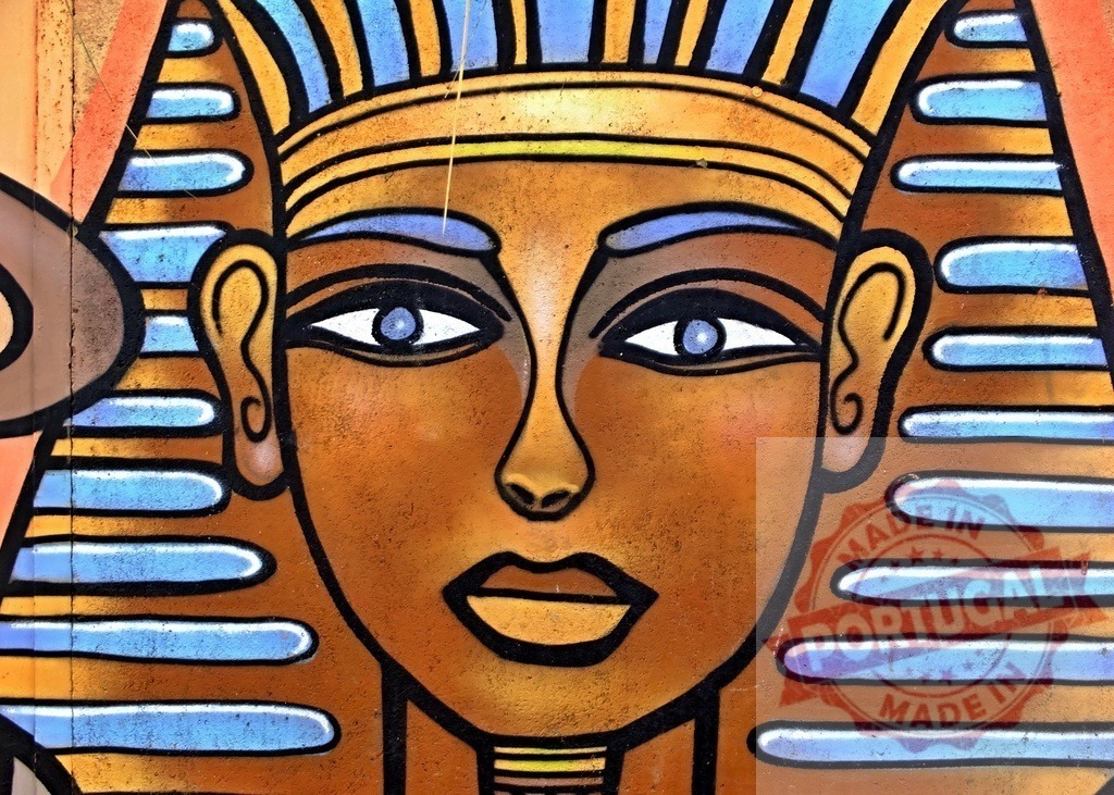 Egyptian pharaoh Tutankhamun street art mural painting | Urban wall featuring vibrant graffiti painting of a pharaoh's head with Tutankhamun's iconic golden mask - Realized with Pictrs.com