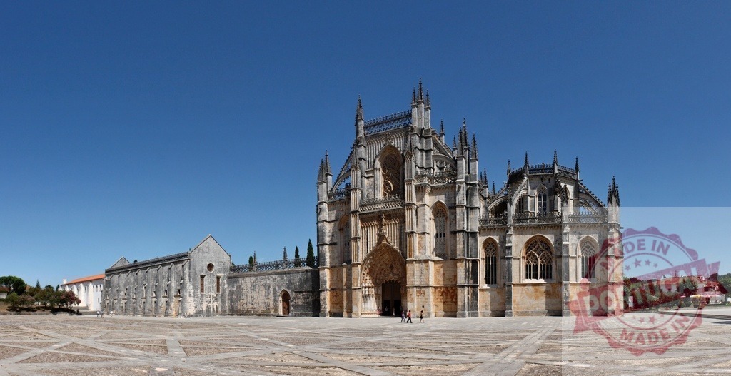 Batalha Monastery displaying Gothic and Manueline architectural styles in Portugal. Centro - Portugal | Batalha Monastery stands under a clear blue sky, presenting its detailed Gothic and Manueline architecture - Realisiert mit Pictrs.com