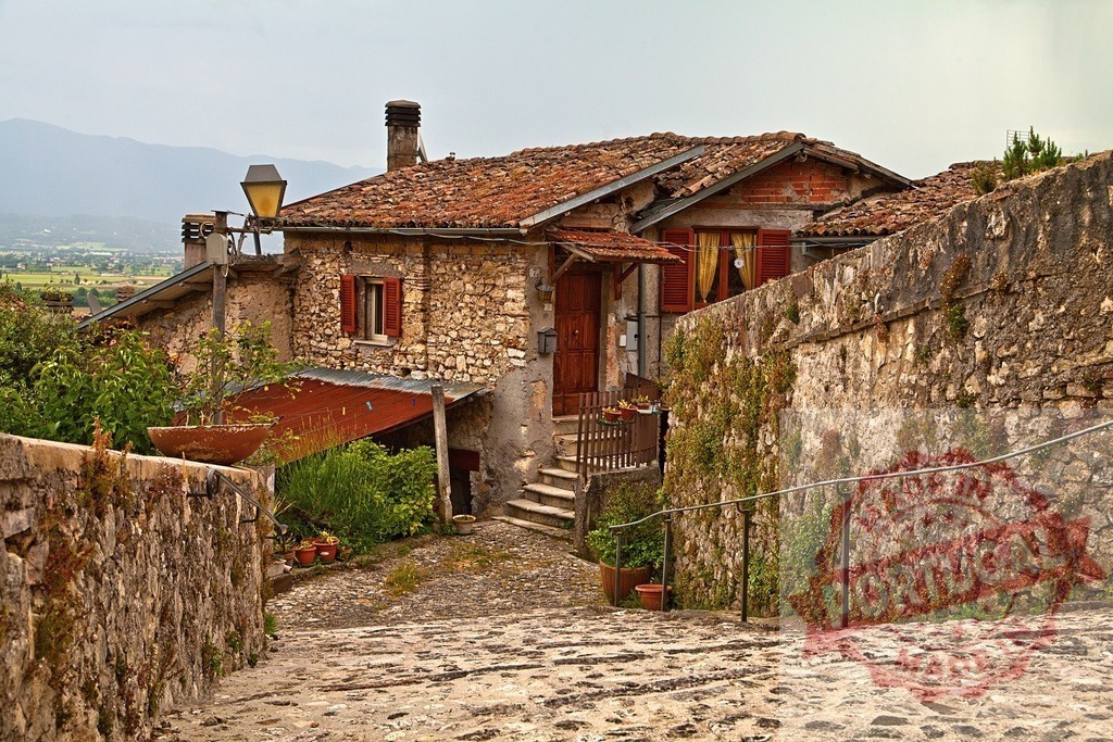 Italian village stone house and cobblestone street | Traditional stone house with terracotta roof along a rustic cobblestone street in Italy - Realized with Pictrs.com