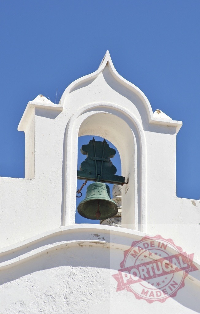 White bell tower architecture against blue sky. Algarve - Portugal | White bell tower with a bronze bell framed against a clear blue sky - Realized with Pictrs.com
