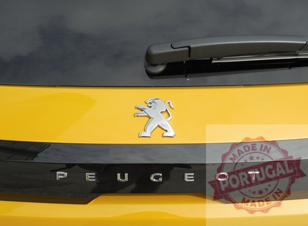 Peugeot emblem and text on yellow car trunk | Peugeot lion logo and letters on rear trunk of modern yellow car - Realisiert mit Pictrs.com