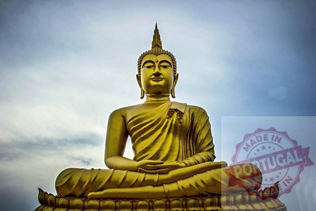 Big golden Buddha statue meditating peacefully under cloudy sky | Large golden Buddha statue in meditation pose with serene expression, under a cloudy sky, inspiring peace and tranquility - Realized with Pictrs.com
