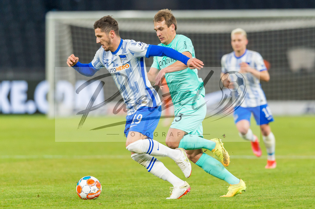 HERBOC20220204_011 | Fussball, Herren: Robert Tesche (VfL Bochum) und Stevan Jovetic (Hertha BSC) im Zweikampf bei dem Spiel der 1. Bundesliga zwischen Hertha BSC und VfL Bochum im Olypiastadion am 04.02.2022 in Berlin, Deutschland.DFB / DFL REGULATIONS PROHIBIT ANY USE OF PHOTOGRAPHS AS IMAGE SEQUENCES AND/OR QUASI-VIDEO. - Realisiert mit Pictrs.com