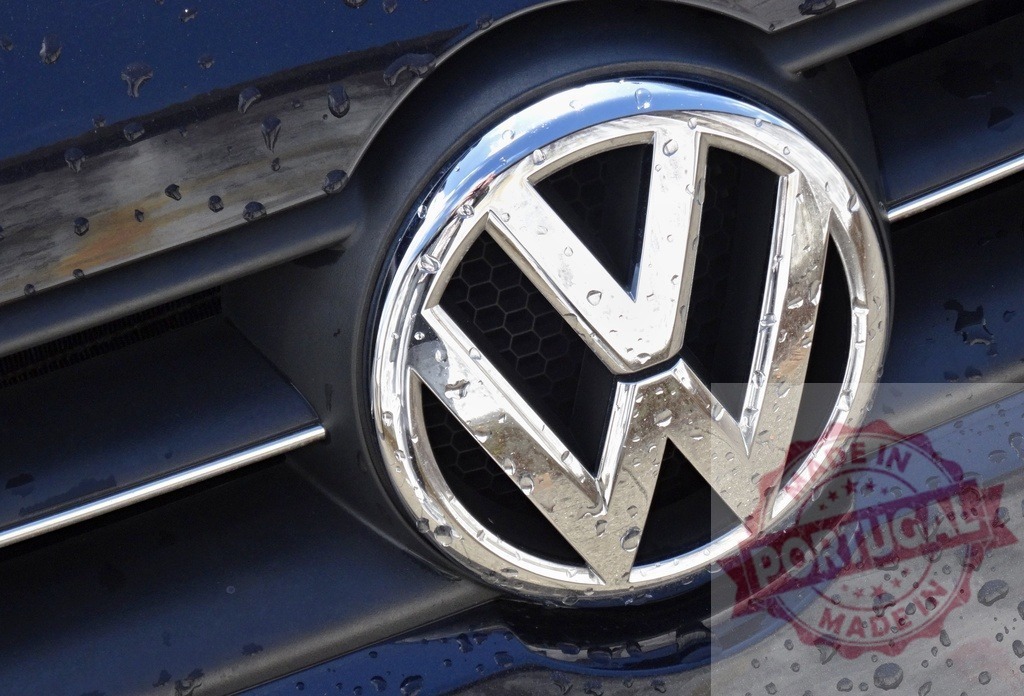 Volkswagen logo on car grill with raindrops | Volkswagen chrome emblem on a wet vehicle grill after rain - Realisiert mit Pictrs.com