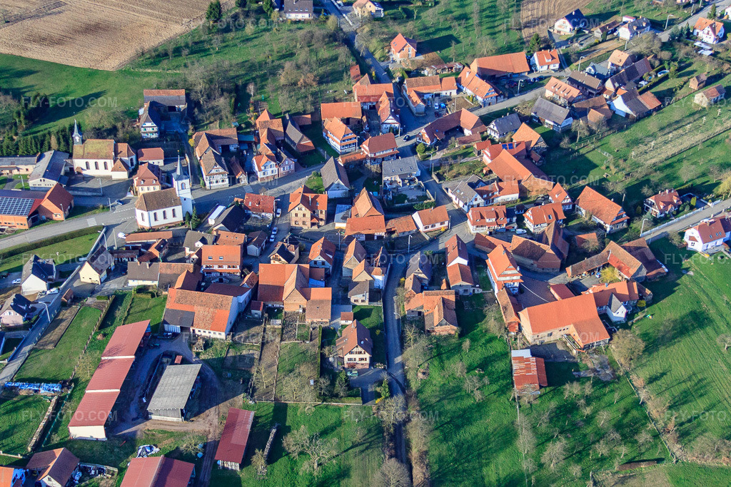 Aerial view: Village with Catholic Church of Saint George and Protestant Church of the South in Keffenach in the state Bas-Rhin, France. – Photo: IMG_38759.jpg taken on 03/20/2011 by Werner Riehm/FLY-FOTO.com – Resolution of the original: 4396 x 2931 px
