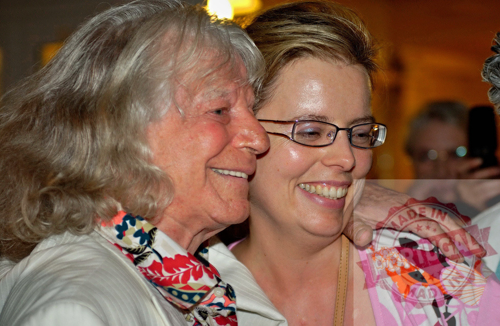 Elderly woman and young woman smiling and embracing | Elderly woman and young woman hugging and smiling, showing connection and affection - Realized with Pictrs.com