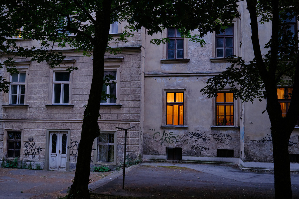 Wohnhaus mit beleuchtetem Fenster am Abend | Ljubljana, Slowenien - June 22, 2025: Wohnhaus mit beleuchtetem Fenster am Abend. - Realisiert mit Pictrs.com