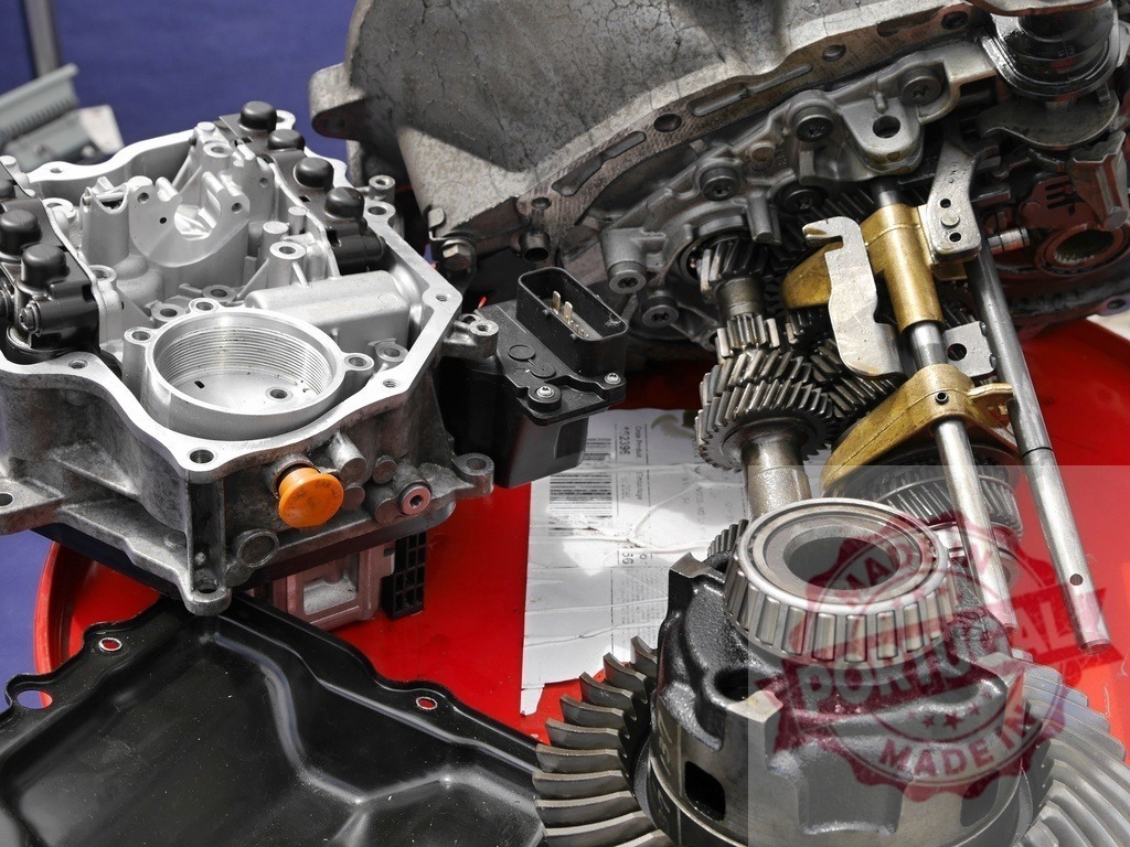 Car automatic transmission parts and gears disassembled for repair | Disassembled automatic transmission parts, gears, and metallic components on a red background - Realisiert mit Pictrs.com