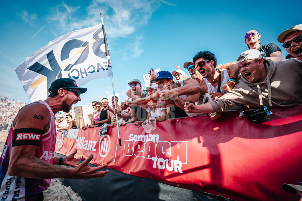 Beachvolleyball | Männer | Allianz German Beach Tour | Deutsche Beachvolleyball-Meisterschaft 2024 | 31.08.2024 | Jonathan Erdmann jubelt nach dem Sieg mit dem Fanclub des 1. Beachclub Kiel BCK
