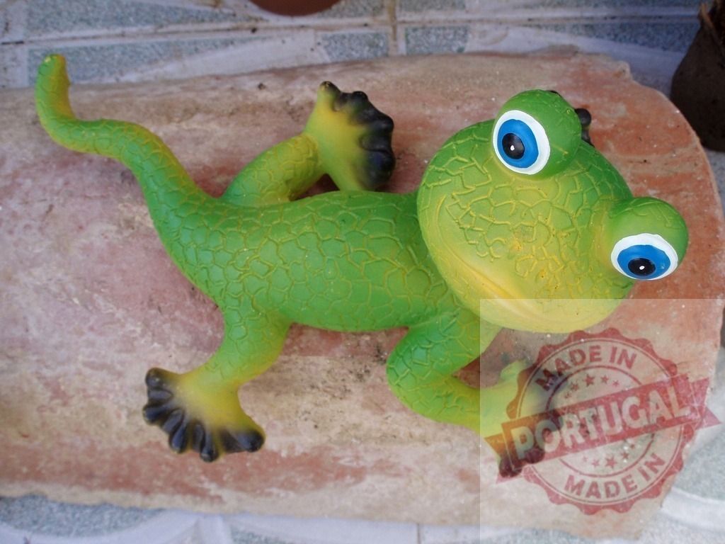 Green gecko garden ornament with big blue eyes | Green gecko garden ornament with big blue eyes resting on a rock - Realized with Pictrs.com