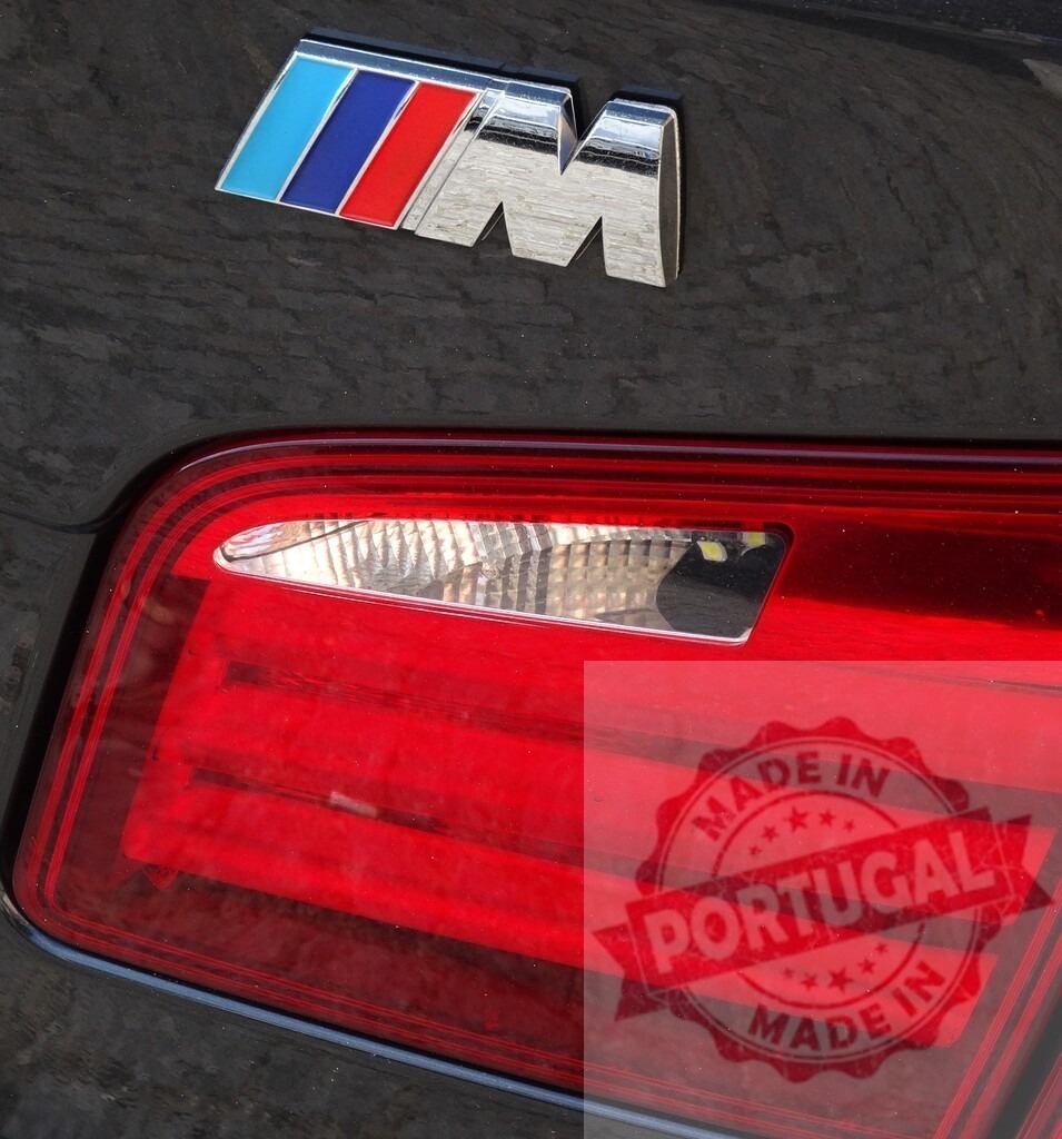 BMW M car logo and red taillight detail | BMW M logo and red taillight on a black performance automobile - Realized with Pictrs.com