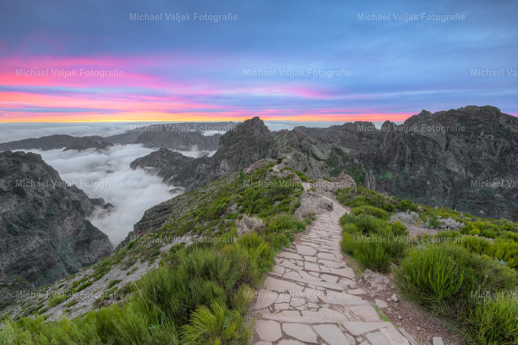 Abends auf dem Pico do Arieiro auf Madeira | Kurz nach Sonnenuntergang bietet der Pico do Arieiro auf Madeira einen atemberaubenden Anblick. Die bereits untergegangene Sonne taucht den Himmel in tiefe Orange-/Rottönen und sanfte Violettschattierungen. Die Wolken, die sich unterhalb des Gipfels sammeln, verleihen dem Bild eine fast magische Atmosphäre.Dieser Moment auf dem dritthöchsten Gipfel Madeiras ist ein wahres Naturschauspiel, das die Schönheit und Erhabenheit der Insel eindrucksvoll zur Geltung bringt. Es ist ein Ort, der zum Innehalten und Staunen einlädt, während die Natur ihre abendliche Ruhe findet. - Realisiert mit Pictrs.com