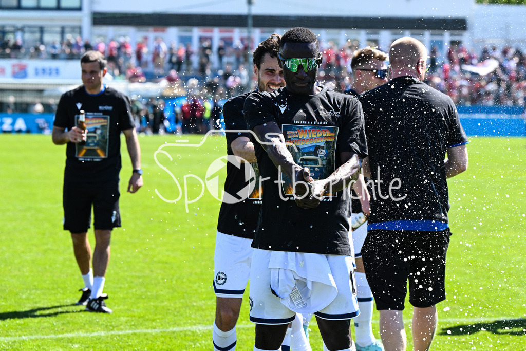 SpVgg Unterhaching - Arminia Bielefeld | die Mannschaft aus Bielefeld feiert zusammen mit den Fans dein Sieg und den Aufstieg in Unterhaching / Bierdursche / Bier / Freude / Happy / Gluecklich / 3. Liga: SpVgg Unterhaching - Arminia Bielefeld, Uhlsport Park am 11.05.2025 / Merveille BIANKADI (Arminia Bielefeld 17)