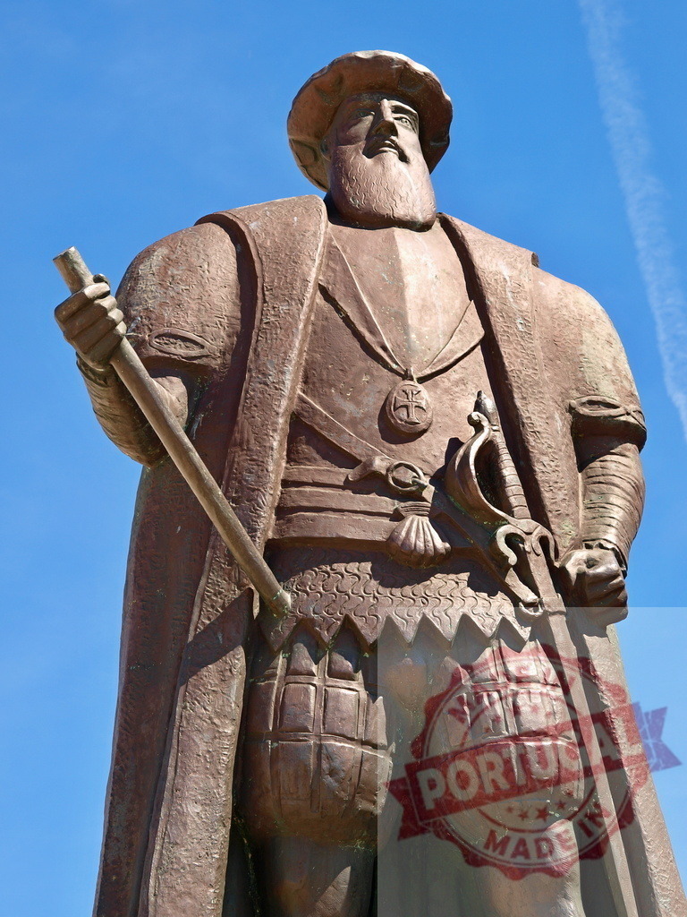 Vasco da Gama statue exploring horizon under blue sky | Bronze statue of Portuguese explorer Vasco da Gama standing against a clear blue sky - Realized with Pictrs.com