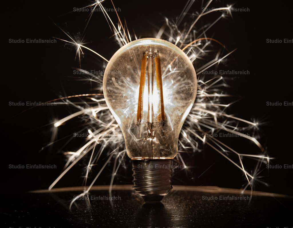 Zündung – Glühbirne mit Funken | Eine klassische Glühbirne, umgeben von sprühenden Funken – ein Sinnbild für Idee, Energie und den Moment des Aufleuchtens. Dynamik und Wärme in einem kraftvollen Motiv. Ideal für Büro, Werkstatt oder kreative Räume. Als Fine-Art-Print und Wandbild in verschiedenen Größen erhältlich. - Realisiert mit Pictrs.com