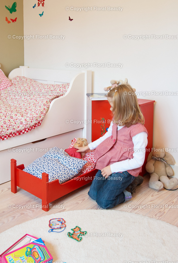 Kinderzimmer | Kind spielt mit Puppe im Puppenbettchen - Realisiert mit Pictrs.com