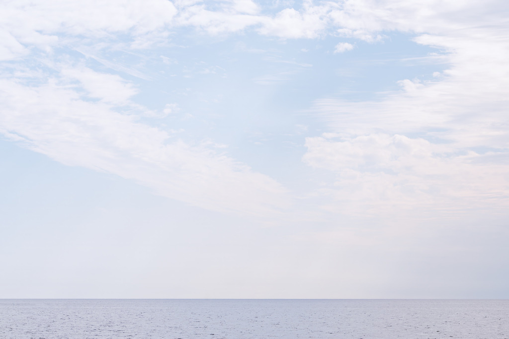 Weite des Himmels – Minimalistisches Meeresbild in sanften Tönen | Dieses FineArt‑Wandbild zeigt eine ruhige Meeresfläche unter einem weit geöffneten Himmel mit zarten Wolkenstrukturen. Die klare Horizontlinie und die sanfte Farbpalette verleihen dem Motiv eine konsequent minimalistische Wirkung. Die offene Weite und die stille Atmosphäre schaffen ein zeitloses, reduziertes Kunstwerk, das moderne, puristische Räume mit Leichtigkeit und Eleganz ergänzt.