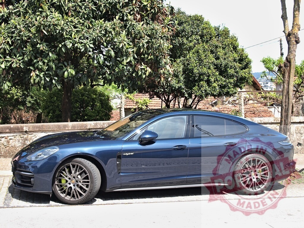 Blue Porsche Panamera hybrid car parked outdoors | Blue Porsche Panamera premium sport sedan parked on a sunny day - Realisiert mit Pictrs.com