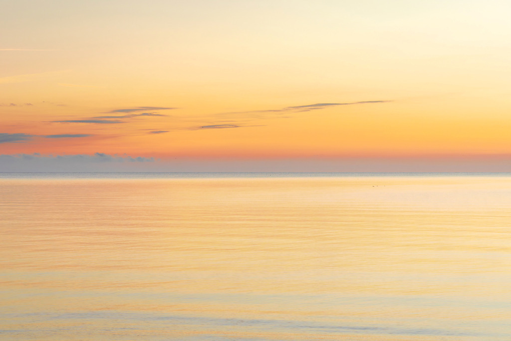 Wandbild: Morgenrot am Strand in Kronsgaard | Ein traumhafter Morgen am Strand von Kronsgaard – der Himmel erstrahlt in sanften Orangetönen und spiegelt sich im ruhigen Meer. Die harmonische Lichtstimmung fängt die friedliche Atmosphäre der Küste ein und bringt ein Gefühl von Weite und Entspannung direkt in Ihr Zuhause. Ein ideales Wandbild für alle, die die Schönheit maritimer Sonnenaufgänge schätzen und sich täglich eine Prise Ruhe gönnen möchten. - Realisiert mit Pictrs.com