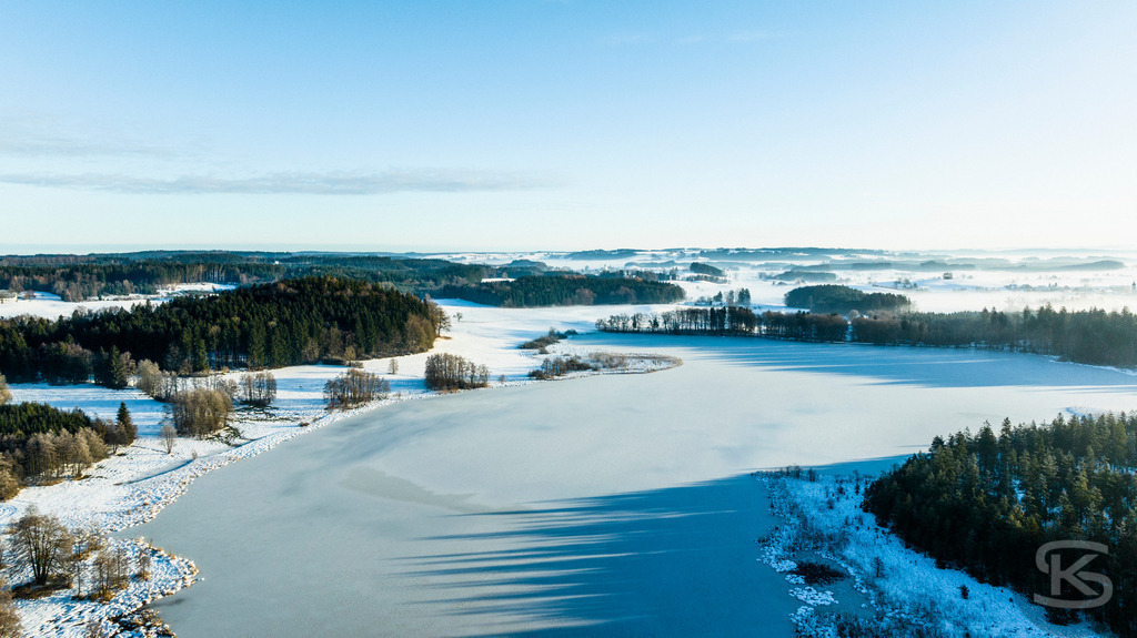 Wunderschöne Allgäu-Winterlandschaft aus der Luft – Hügel, Wälder und Alpenpanorama | Wunderschöne Allgäu-Winterlandschaft aus der Luft mit sanften Hügeln, verschneiten Wäldern und beeindruckendem Ausblicküber einen zugefrorenen See – ruhige, klare Winteridylle in einzigartiger Vogelperspektive. - Realisiert mit Pictrs.com