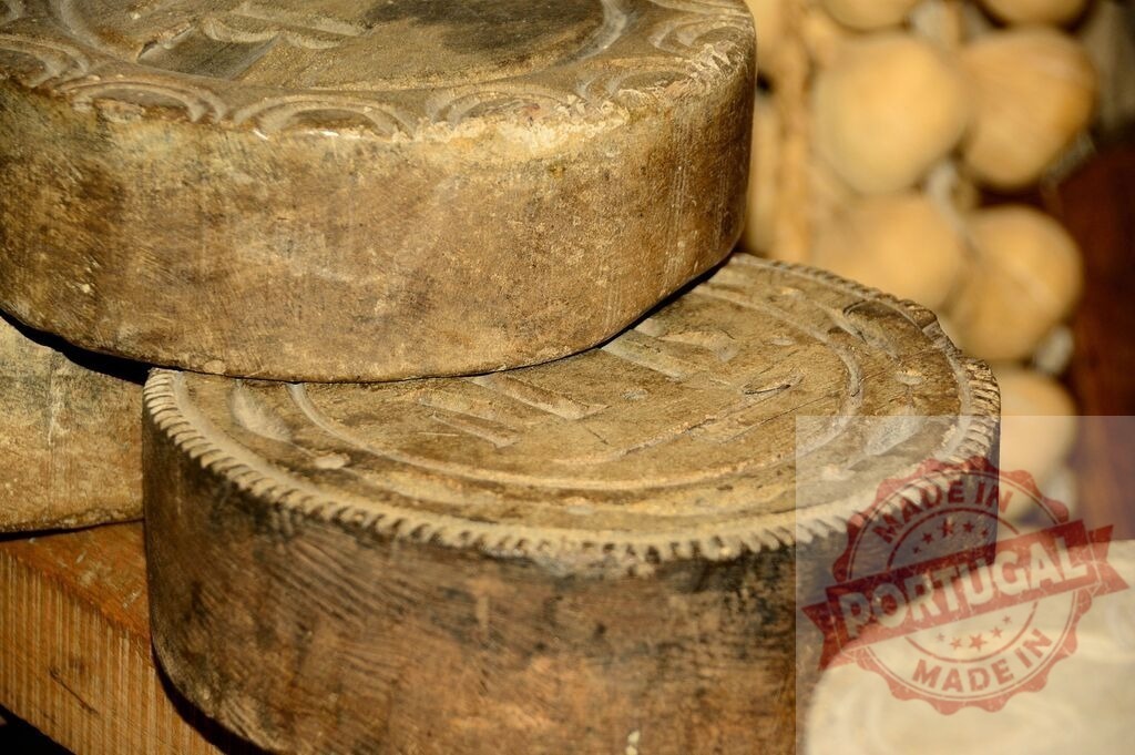 Rustic wooden cheese molds displaying traditional craftsmanship | Stacked antique wooden cheese molds with intricate patterns ready for use - Realized with Pictrs.com