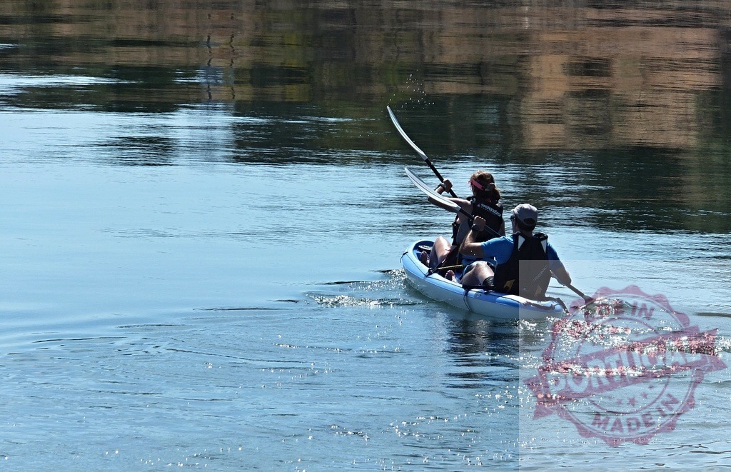 Couple paddling tandem kayak on calm lake water | Couple enjoying kayaking together on a peaceful lake during summer - Realisiert mit Pictrs.com