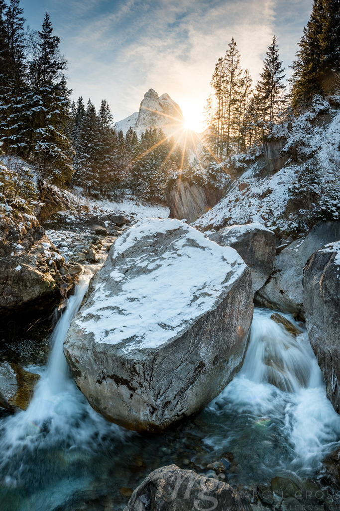 winter sun shining through the forest an Wetterhorn over Rychenbach creek in Rosenlaui Valley | Die ideale Geschenkidee für Naturliebhaber. Naturbilder von Marcel Gross Photography für ihr Zuhause in den verschiedensten Formaten und Materialien. - Realisiert mit Pictrs.com