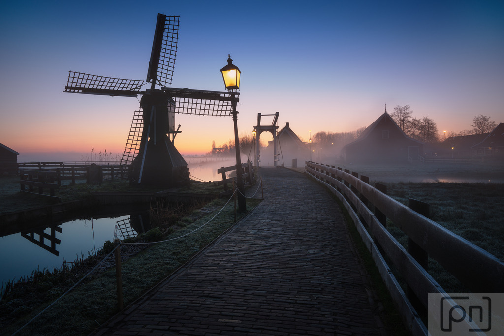 Zaanse Schans Niederlande | "Zaanse Schans Fotos" präsentieren eine zauberhafte Reise in die Vergangenheit der Niederlande. Die Zaanse Schans ist ein malerisches Dorf, das sich in der Nähe von Amsterdam befindet und als lebendiges Freilichtmuseum bekannt ist. Die Fotos zeigen die einzigartige Atmosphäre dieses historischen Ortes, der eine Fülle von traditionellen Windmühlen, Holzhäusern, Brücken und Kanälen umfasst.

Die Windmühlen sind zweifellos die Hauptattraktion der Zaanse Schans. Die Fotos fangen die majestätische Präsenz dieser Windmühlen ein, die einst das industrielle Herz der Region bildeten. Jede Mühle hat ihre eigene Geschichte und diente einst verschiedenen Zwecken wie dem Mahlen von Getreide, dem Sägen von Holz oder der Herstellung von Farben und Ölen.

Die Bilder zeigen auch die charakteristischen grünen Holzhäuser, die typisch für die niederländische Architektur sind und eine gemütliche und idyllische Atmosphäre schaffen. Die Schönheit der Zaanse Schans wird durch die Spiegelungen der Häuser in den Kanälen verstärkt, die eine malerische Kulisse für die Fotografien bieten.

Die Fotos erfassen die Traditionen und das Handwerk der Vergangenheit, die in der Zaanse Schans lebendig gehalten werden. Besucher haben die Möglichkeit, Handwerker bei der Arbeit zu beobachten und alte Techniken wie das Herstellen von Holzschuhen, Käse und Schokolade zu erleben.

Inmitten dieser charmanten Kulisse fangen die Fotos das Gefühl von Ruhe und Nostalgie ein, das die Zaanse Schans so besonders macht. Es ist eine Zeitreise in die niederländische Geschichte und Kultur, die Besucher und Betrachter gleichermaßen verzaubert und inspiriert.

Ob Sie von der Erkundung historischer Stätten fasziniert sind oder einfach nur die Schönheit und den Charme der Zaanse Schans bewundern möchten, diese Fotos bieten einen unvergesslichen Einblick in diese einzigartige Perle der niederländischen Landschaft
