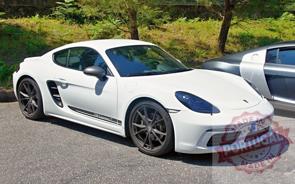 White Porsche 718 Cayman T parked near an Audi R8 | Modern white Porsche 718 Cayman T parked in a parking lot near an Audi R8 - Realisiert mit Pictrs.com