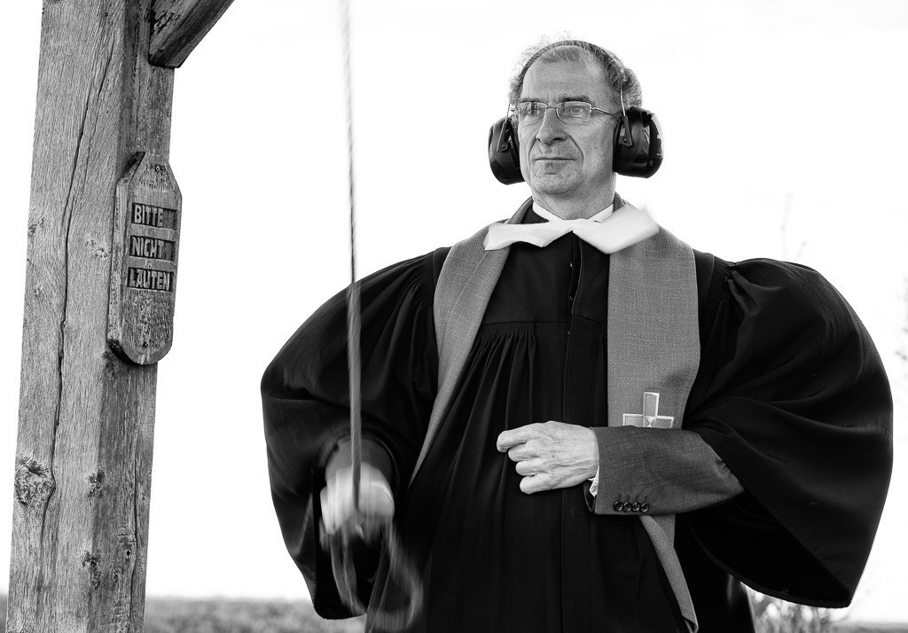 Pastor Matthias Krämer vor der Halligkirche Langeneß © Holger Rüdel | Der Online-Shop von Holger Rüdel. Ausgewählte Fotografien als FineArt-Prints bestellen: Bildreportagen, Landschaften, Wildlife, History, Infrarot-Motive in Schwarzweiß und Verschiedenes.  - Realisiert mit Pictrs.com