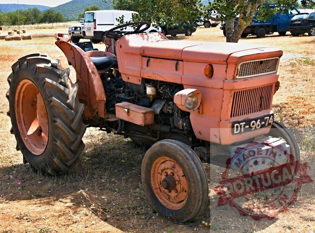 Vintage orange tractor parked in a rural field | Old Fiat tractor standing on dry ground on a sunny day - Realized with Pictrs.com