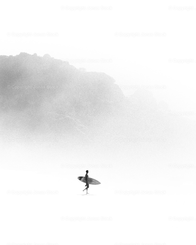 Surfer b/w  | Surfer on his way to the Ocean during a foggy evening.  - Realisiert mit Pictrs.com