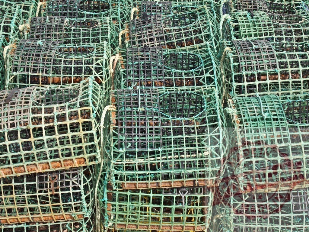 Fishing lobster traps stacked preparing for marine industry | Stacked commercial lobster traps creating a patterned background for fishing industry - Realized with Pictrs.com