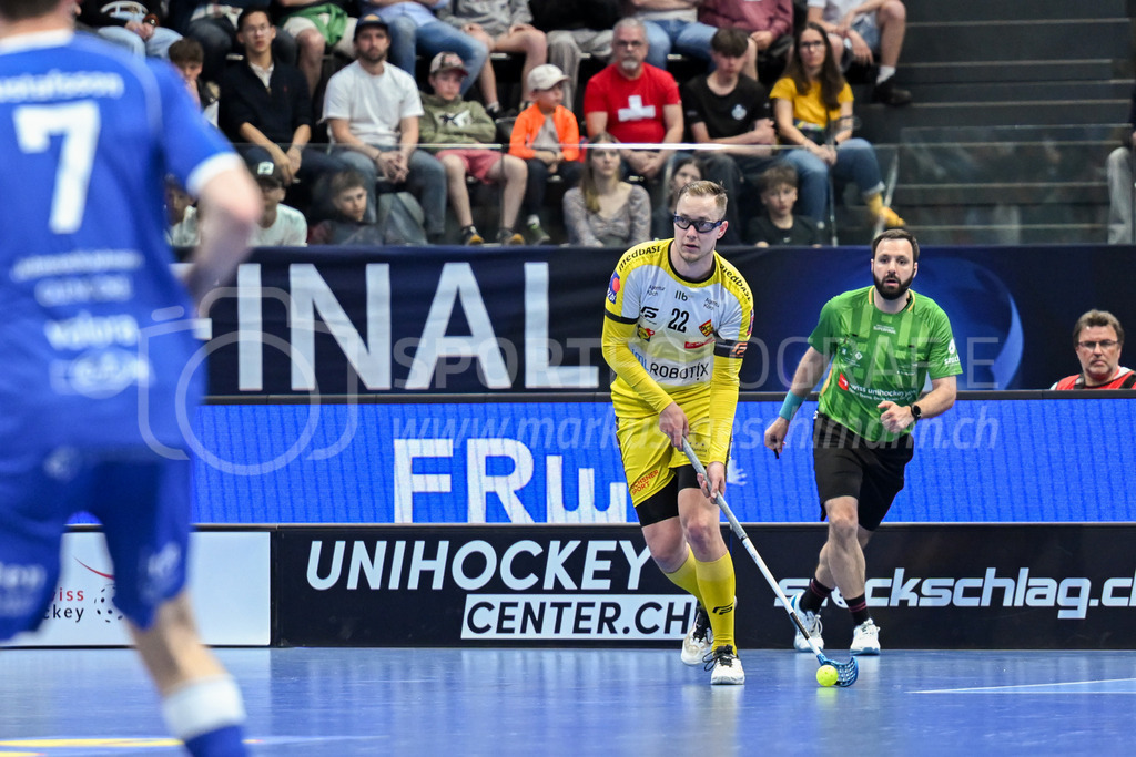 Zug United - HC Rychenberg - 25. April 2026 | Michel Wöcke (#22 HC Rychenberg Winterthur), hinten Schiedsrichter Benjamin Schläpfer am L-UPL Superfinal-Spiel zwischen Zug United und HC Rychenberg am 25. April 2026 in der BCF Arena, Fribourg, Schweiz.Bild: Sportfotografie Markus Aeschimann | www.markus-aeschimann.ch - Realized with Pictrs.com