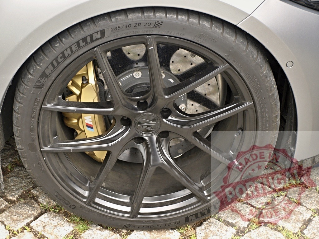 BMW M car wheel with gold M caliper | BMW M Series wheel featuring a black alloy rim, a Michelin Pilot Sport tire, and gold brake caliper - Realisiert mit Pictrs.com