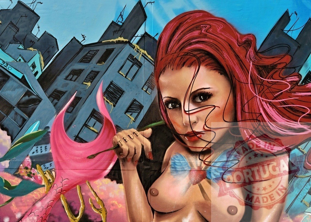 Red haired woman painting a mermaid in a urban setting | Urban art representing a red haired woman painting a mermaid with the word truth written on her hand - Realized with Pictrs.com