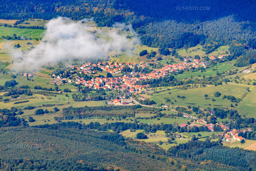 Aerial view: Village view from the southeast under clouds in Wingen in the state Bas-Rhin, France. – Photo: IMG_21018.jpg taken on 09/06/2009 by Werner Riehm/FLY-FOTO.com – Resolution of the original: 4717 x 3145 px