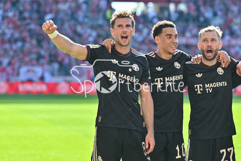 1. FSV Mainz 05 - FC Bayern München | MAINZ, GERMANY - 25. APRIL: die Spieler der Bayern feiern zusammen mit den Fans den Auswärtssieg in Mainz nach dem Bundesligamatch zwischen dem 1. FSV Mainz 05 und dem FC Bayern München am 31. Spieltag in der MEWA Arena / DFL REGULATIONS PROHIBIT ANY USE OF PHOTOGRAPHS AS IMAGE SEQUENCES AND/OR QUASI-VIDEO / Leon GORETZKA (FC Bayern Munich 8), Jamal MUSIALA (FC Bayern Munich 10), Konrad LAIMER (FC Bayern Munich 27)