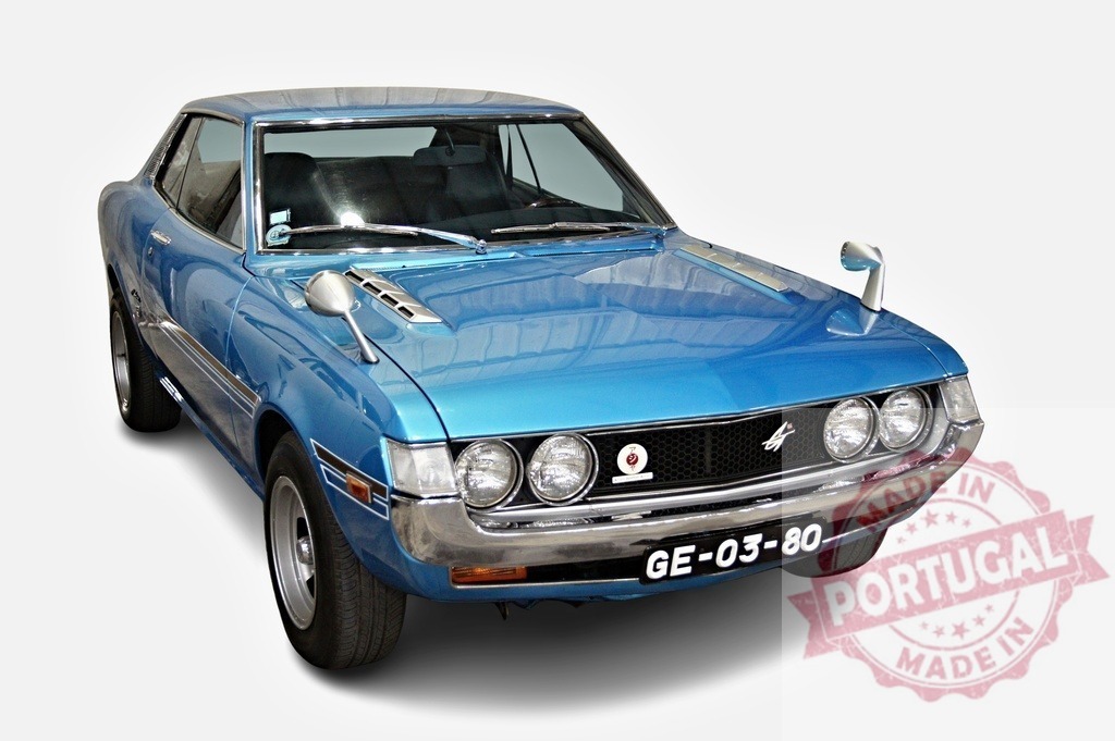 Toyota Celica ST liftback coupe posing in a studio | Classic blue Toyota Celica ST liftback coupe from seventies with custom chrome mirrors and hood vents posing in a white studio - Realized with Pictrs.com