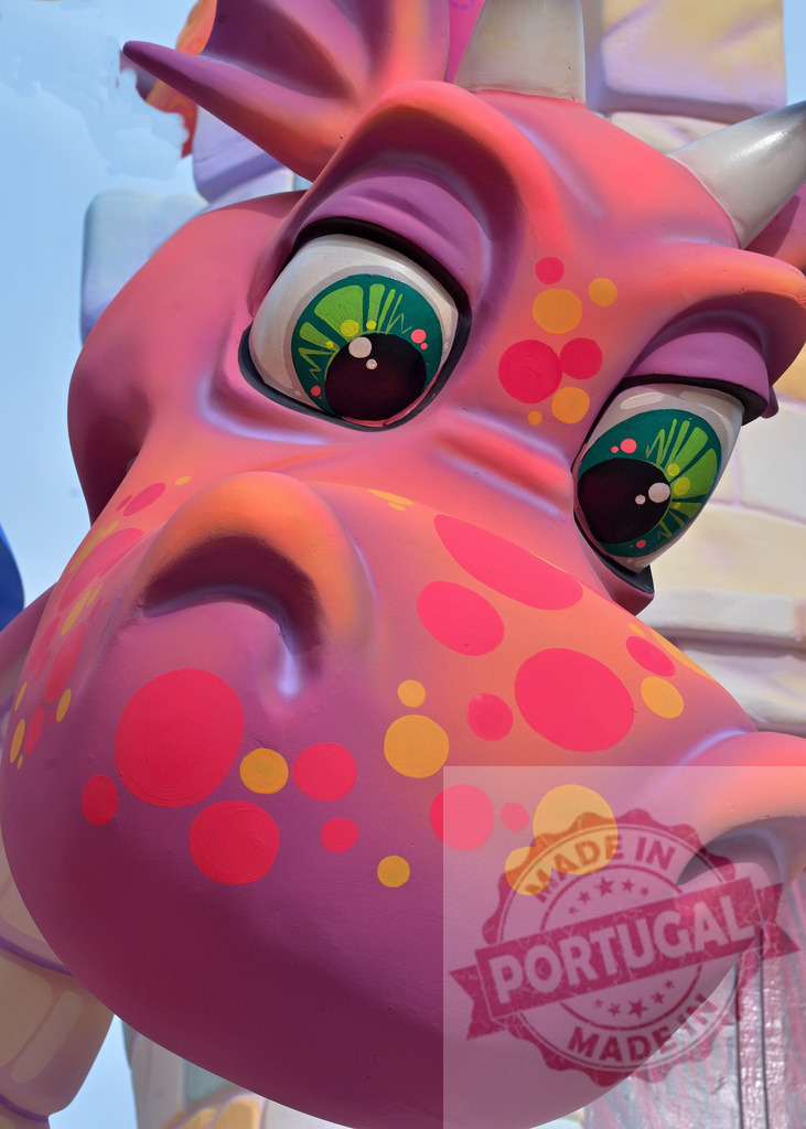 Pink cartoon dragon sculpture with green eyes and polka dots. Fallas Fiestas Communidad Valenciana | Close-up of a colorful cartoon dragon sculpture, displaying expressive green eyes and vibrant polka dots - Realisiert mit Pictrs.com