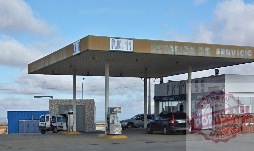 Gas station P.K. 11 offering refueling services in Spain | Cars parked at a roadside service station with fuel pumps and a small shop - Realisiert mit Pictrs.com