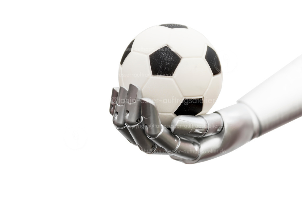 Robot is holding a football | Eine Maschine erreicht den Fußball. Roboter-Hand mit kleinen Fußball isoliert gegen weißen Hintergrund