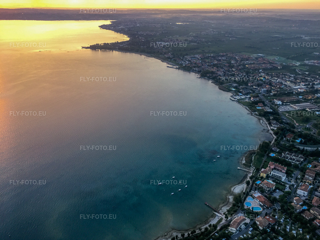 Vue aérienne: Lever de soleil sur le lac de Garde à Sirmione dans le département Brescia, Italie. Photo: IMG-134991.jpg prise le 23/09/2022 par Werner Riehm/FLY-FOTO.eu – Résolution de l'original: 4032 x 3024 px