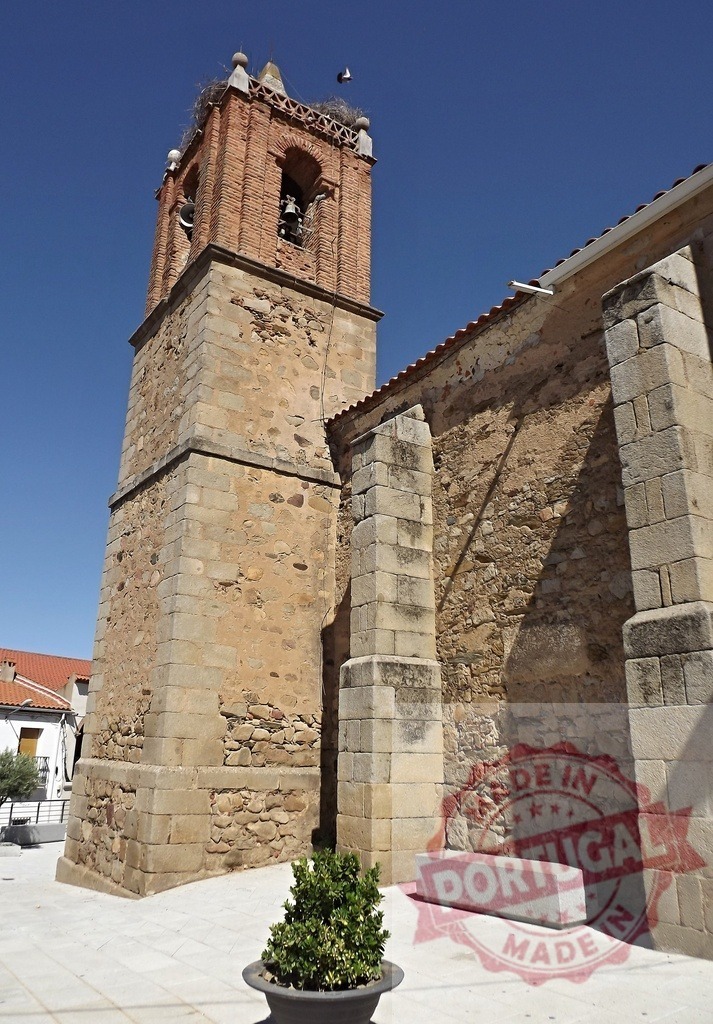 Village church bell tower with stork nest. Spain - Extremadura | Historic church bell tower featuring traditional brick and stone masonry under clear blue sky - Realized with Pictrs.com