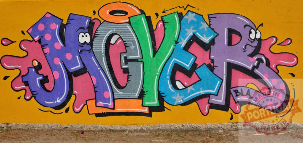 Funny colorful graffiti lettering with faces on a yellow wall | Colorful jmoyer graffiti lettering with funny faces on a yellow wall - Realisiert mit Pictrs.com