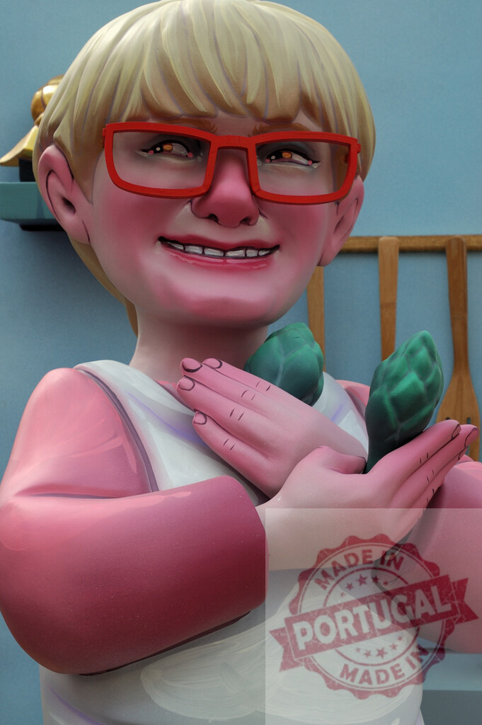 Las Fallas caricature woman holding vegetables. Fallas Fiestas Communidad Valenciana | Las Fallas festival caricature statue of a smiling woman wearing red glasses and holding artichokes - Realized with Pictrs.com