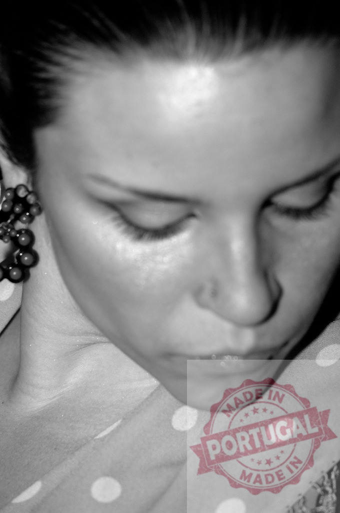 Woman looking down thinking with polka dot scarf | Woman silently reflecting, wearing a polka dot scarf and earring, in a close-up black and white portrait - Realized with Pictrs.com