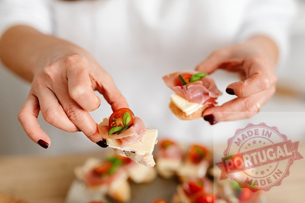 Woman's hands holding gourmet bruschetta appetizers at a party | Woman's hands holding delicious bruschetta with ham, cheese, tomato, and basil - Realisiert mit Pictrs.com